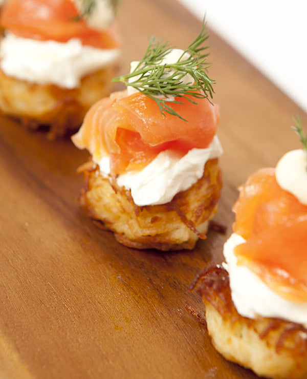 A photo of Mini potato hash browns with Huon smoked salmon dill and Mayonnaise. Perfect for events of all sizes.