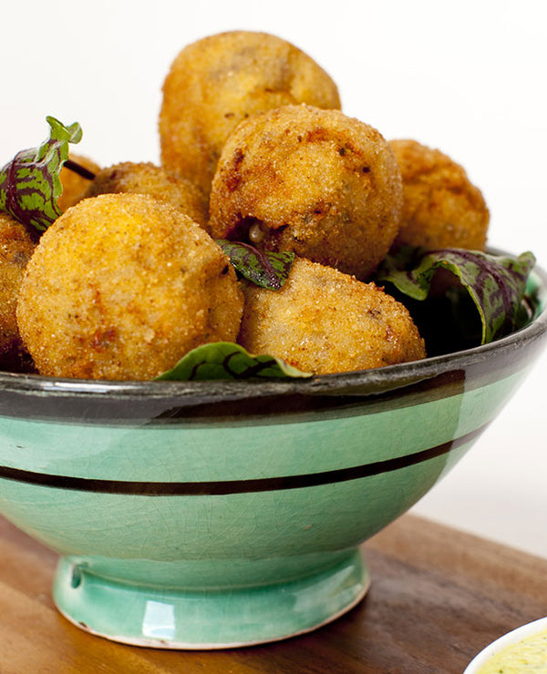 A photo of Mini arancini balls with olives semidried tomatoes and pesto.Perfect for events of all sizes.