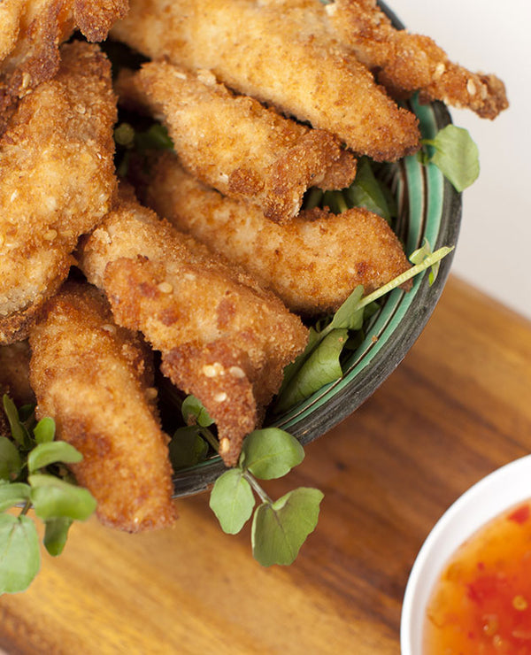 A photo of Tender strips of chicken breast, coated with breadcrumbs and sesame seeds.