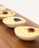 A photo of Mini quiche with Meredith goats cheese, roasted capsicum and topped with kalamata olives.