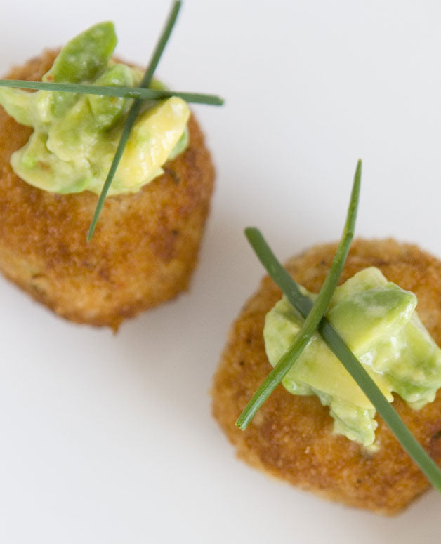 A photo of Mini tuna patties topped with avocado salsa and chives. Perfect for events of all sizes. 