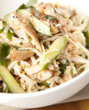 A photo of Spicy Vietnamese noodle salad with Vietnamese mint, marinated chicken thighs, chilli, cashews, and lime. 