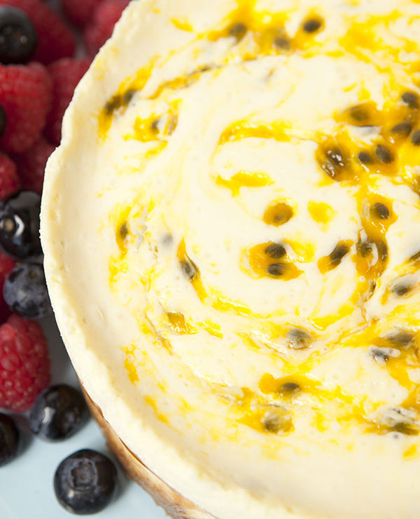 A photo of layered baked cheesecake with a yoghurt sour cream and passionfruit topping.