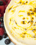A photo of layered baked cheesecake with a yoghurt sour cream and passionfruit topping.